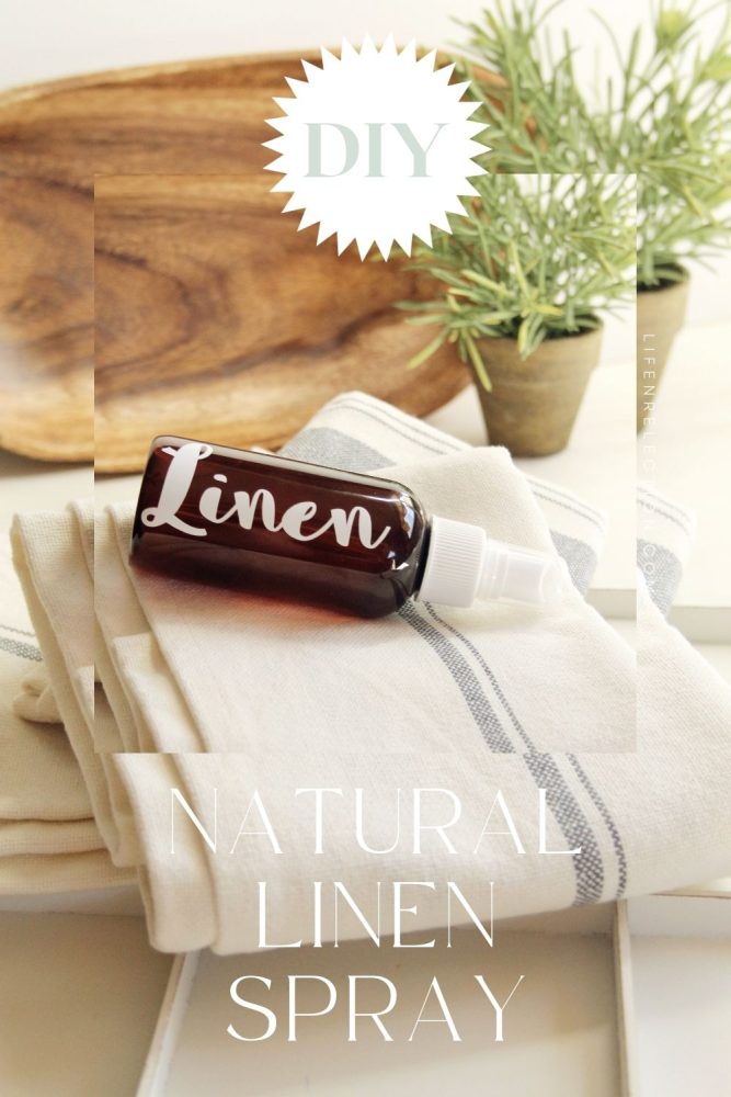 amber colored bottle labeled linen on stack of linen table runners, napkins, and tea towels next to warm wood board and potted plant