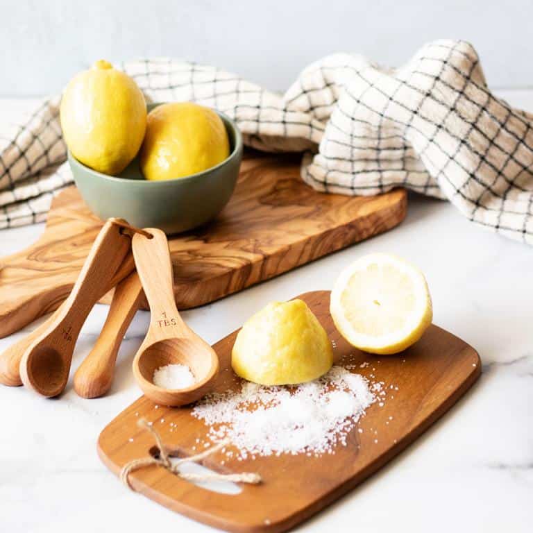 Natural wood cutting boards and measuring spoons with fresh lemons.