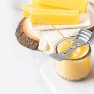 curing beeswax candle next to a bars of beeswax