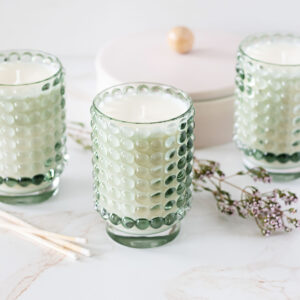 Glamours tall glass candle jars on a marble background