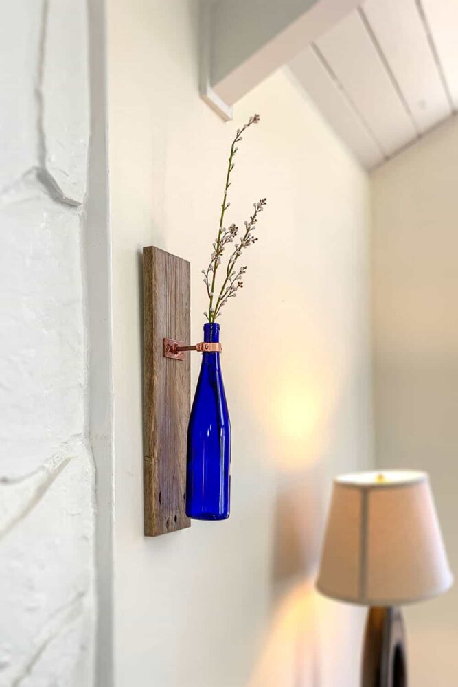 . If you’re willing to put forth the effort, this wine bottle wall vase is not only beautiful but will be a distinctive statement-maker with your guests!