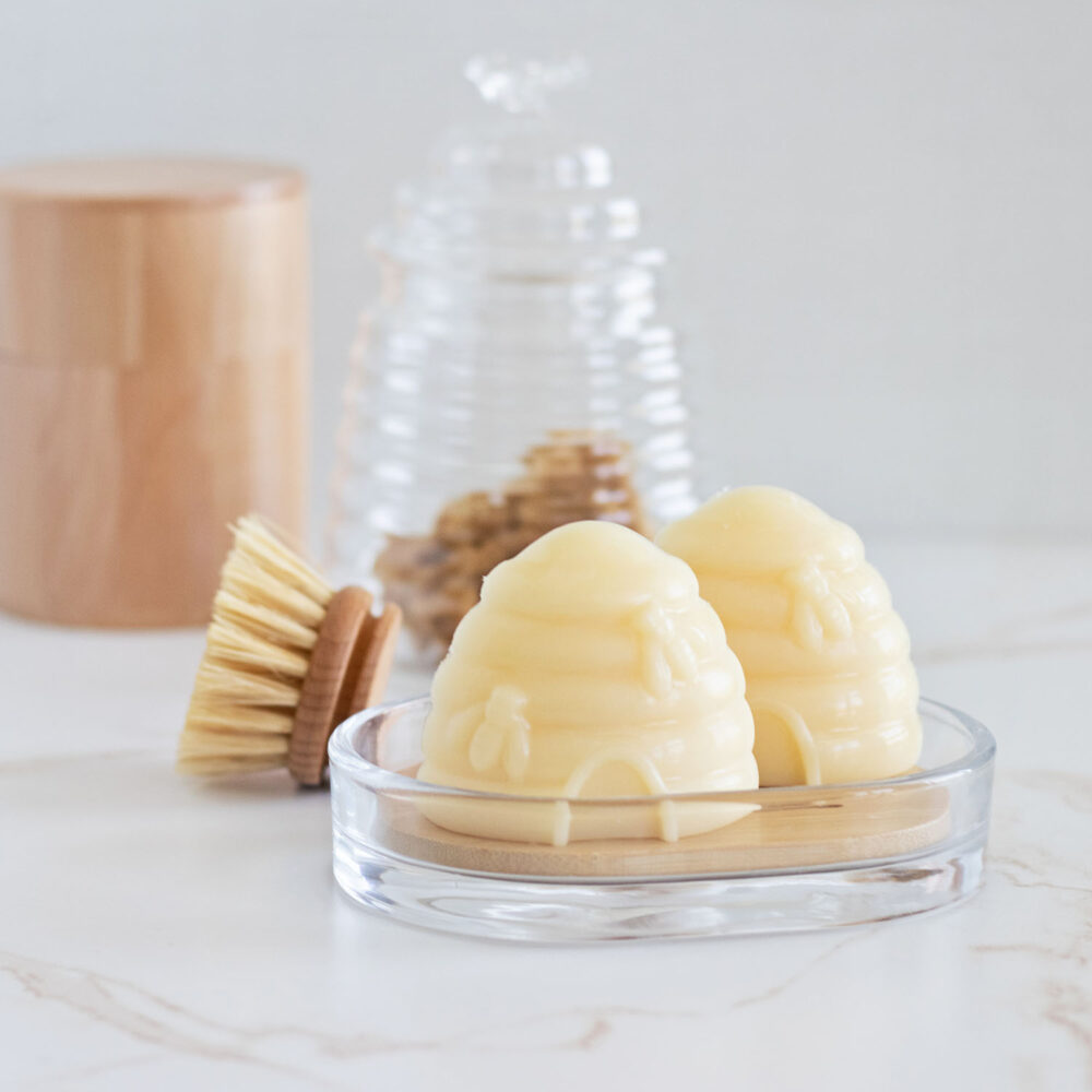 Honeycomb shaped soap bars on wood and glass soap tray on a bathroom counter