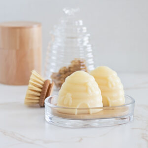 Honeycomb shaped soap bars on wood and glass soap tray on a bathroom counter