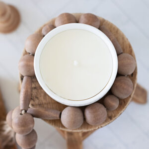 homemade candle in a white bowl on wood candle stand