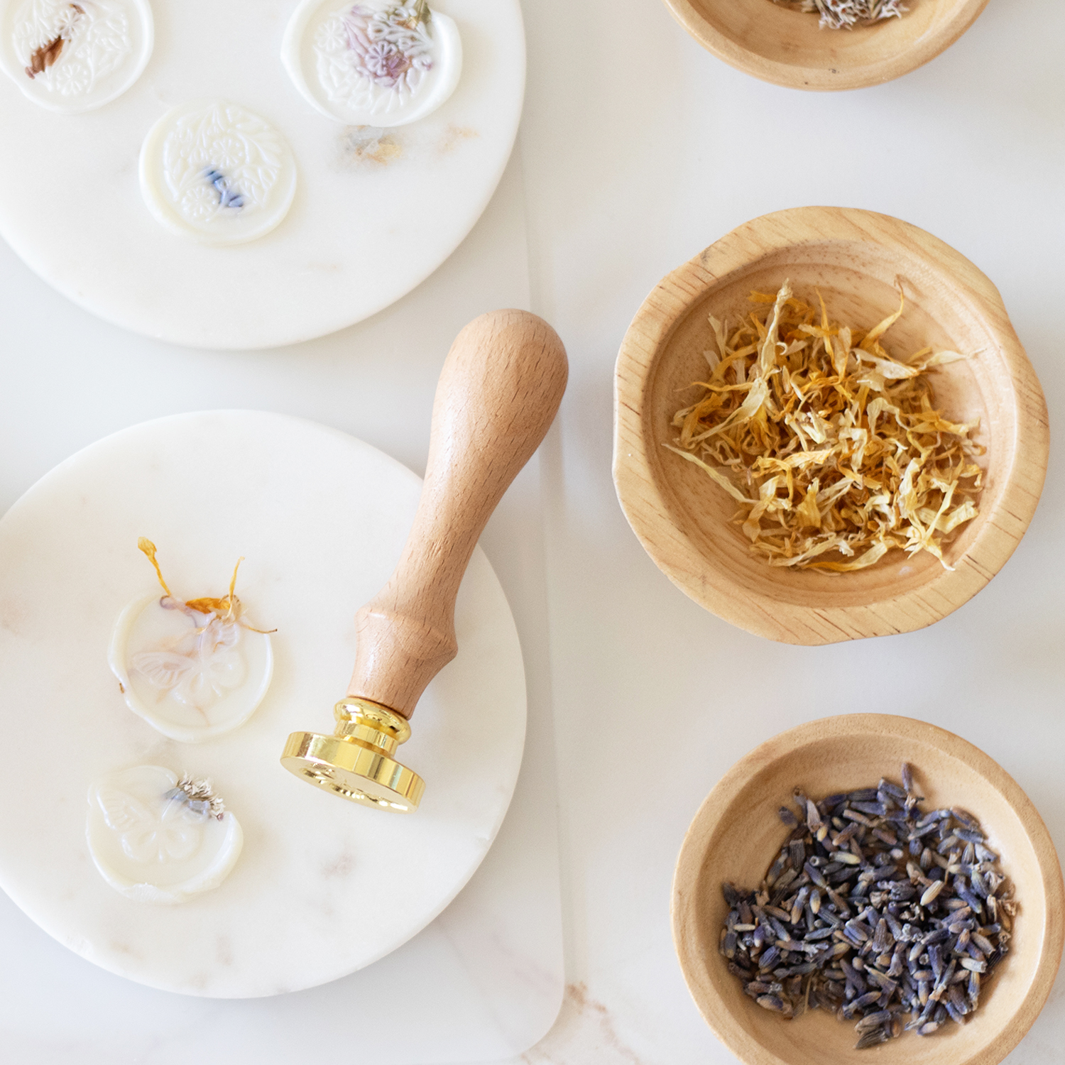 creating floral wax seals bowls of botanicals and wax seal stamp on a light background