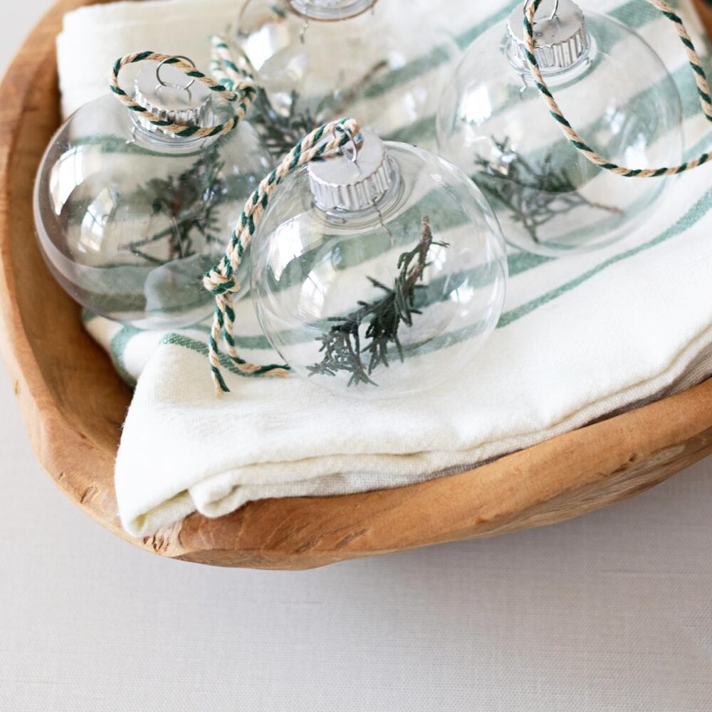 Discover the magic of DIY glass ornaments filled with juniper evergreen when you learn how to create these enchanting holiday treasures!