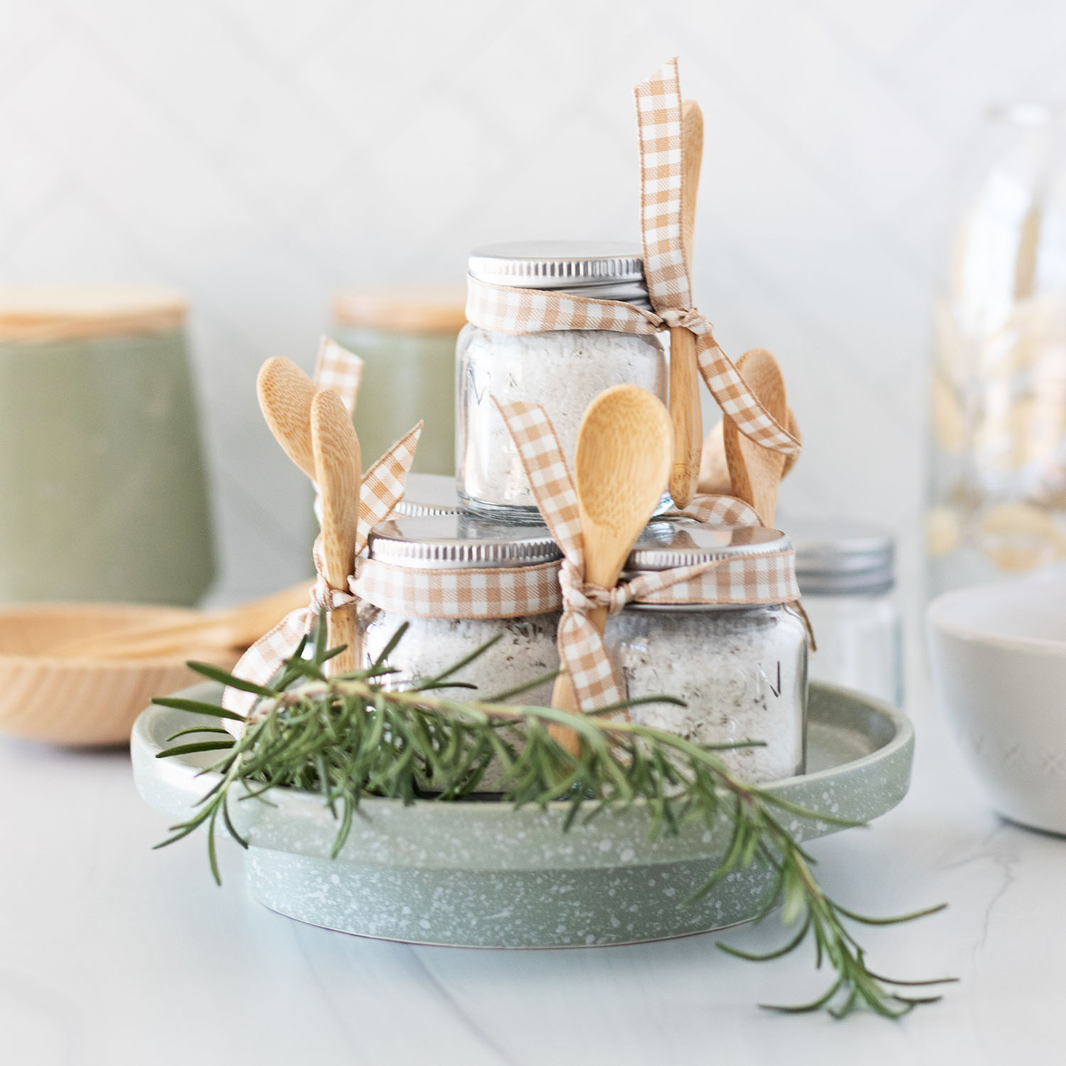 mini mason jars filled with homemade rosemary salts on a kitchen counter