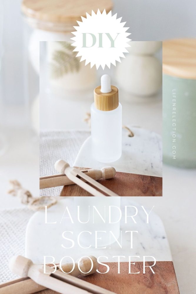 homemade bottle of laundry scent on marble wood board behind wood clothespins. text overlay reads: laundry scent booster