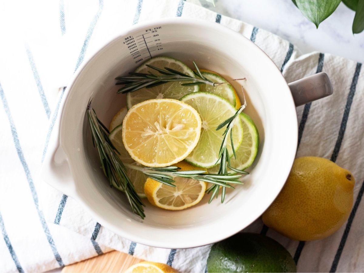 Fresh summer stovetop potpourri Ingredients inside a mason cash bowl on striped blue and white tea towel